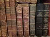many old books that are on a shelf together