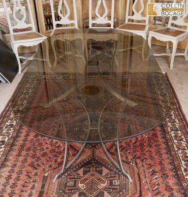 une table avec un plateau en verre et un tapis posé au sol