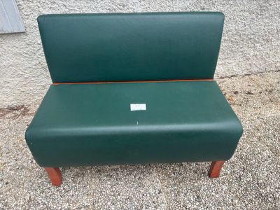 un banc vert sur lequel est accrochée une étiquette