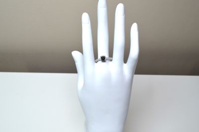a white mannequin hand with a ring on it