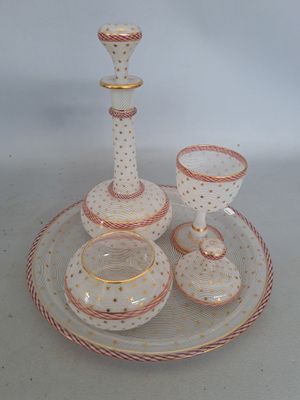 des bougeoirs et des tasses posés sur une assiette, sur un fond blanc