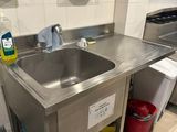 un évier de cuisine avec une poubelle et une poubelle