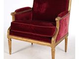 une image représentant une chaise en velours rouge ornée de passementeries dorées