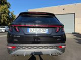 the rear end of a black car parked in a parking lot