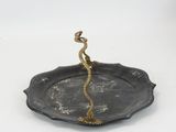 a metal plate with a bird on it on a white surface
