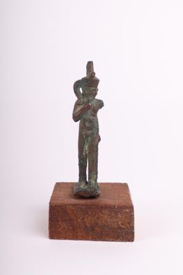 statue représentant un homme tenant un bébé dans ses bras, posée sur un bloc de bois