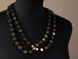 a mannequin with a black and gold necklace on a mannequin