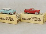 trois petites voitures miniatures sont posées sur une boîte en carton