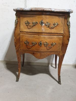 a wooden chest of drawers with a marble top