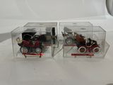 two small toy cars in a clear box on a table