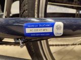 a bicycle with a blue tag attached to it ' s front wheel