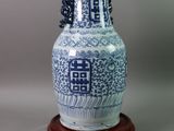 a blue and white vase on a wooden stand