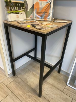 une petite table sur laquelle se trouve un livre, dans une pièce