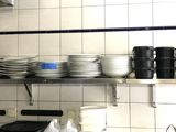 une cuisine avec beaucoup de vaisselle sur les étagères
