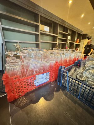 de nombreux verres à vin vides rangés dans des bacs en plastique