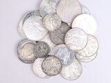 a pile of silver coins sitting on a white surface