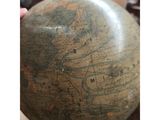 someone is holding a globe in their hand in a room