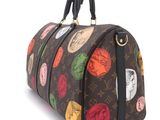 a louis vuitton handbag with a lot of stickers on it