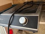 a stove that is sitting on a counter with a cord in it