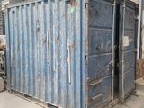 un conteneur d'expédition bleu dans un entrepôt, dont la porte est ouverte