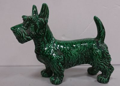 une petite figurine de chien verte posée sur une table