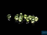 a group of green gems sitting on top of a black surface
