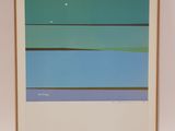 a framed photograph of a blue and green painting on a white wall