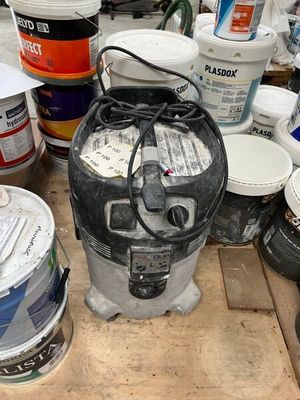 many buckets of paint sitting on a wooden table