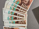 a pile of money sitting on a table next to a laptop