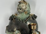 a small statue of a man sitting on top of a vase