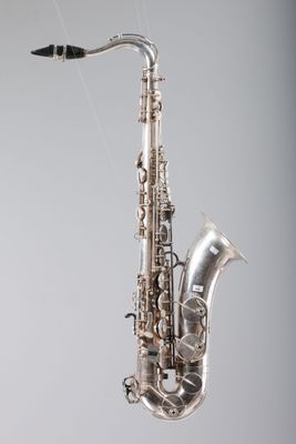 une image représentant un saxophone argenté accroché au mur