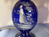 a blue vase that has a picture of a woman on it