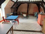 une salle équipée de tables, de chaises et d'un bar