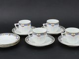 six cups and saucers on a black background