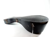 an old black guitar case sitting on top of a white surface
