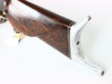 a rifle that is sitting on a white surface