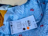 a blue dress with red cherries on it and a price tag attached to it