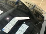 a sticker on the windshield of a car that is parked in a parking lot
