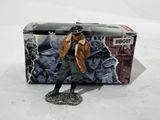 toy figurine of a man in a trench coat and hat standing in front of a box