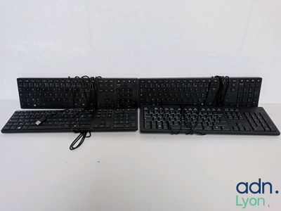 Deux claviers et une souris sont posés sur une surface blanche