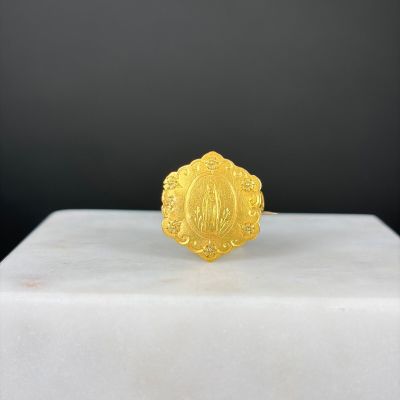 un gros plan d'une bague en or posée sur un bloc de marbre