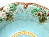 a blue bowl with flowers and leaves on it