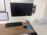 a computer desk with a monitor, keyboard and mouse on it