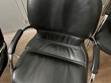 pair of black leather office chairs with chrome legs and armrests