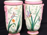 two vases sitting side by side on a black background