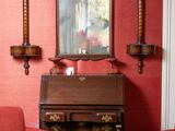 deux fauteuils rouges dans un salon où un miroir est accroché au mur