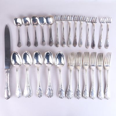 un grand nombre de cuillères et de fourchettes en argent disposées sur une table