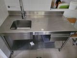 un évier en acier inoxydable et un plan de travail en acier inoxydable dans une cuisine