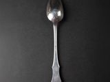 silver spoon on a black table with a black background