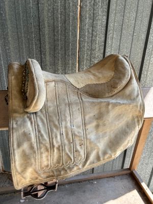 a horse saddle that is sitting on top of a wooden table